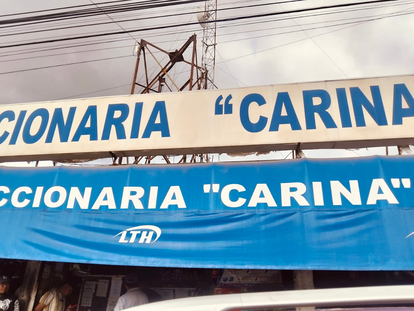 Letrero de Refaccionaria “Carina” sobre el toldo azul